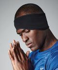 A person wearing a black Beechfield BC316 headband and a blue shirt is shown with their eyes closed and hands together, appearing to be in a moment of meditation or prayer. The background is plain gray.