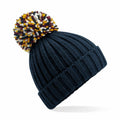 The BC390 by Beechfield is a navy blue knit beanie featuring a colorful pom-pom on top.