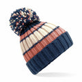 Introducing the BC392 by Beechfield: a knitted winter hat adorned with a large pom-pom and featuring horizontal stripes in navy blue, cream, and pinkish-orange hues. The cuff is designed in a solid navy blue for added style.