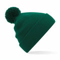 Beechfield BC426 green knit beanie featuring a pom-pom on top, displayed against a white background.