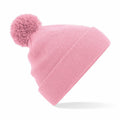 The Beechfield BC426 is a pink knitted beanie with a pom-pom on top, showcased against a white background. It includes a folded brim for enhanced style and warmth.