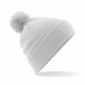 A light gray Beechfield BC426 knit beanie features a folded brim and a fluffy pom-pom on top. It is styled to the side against a white background, showcasing its simple and cozy design.