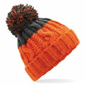 The BC437 by Beechfield is a winter beanie in orange and black, featuring a large pom-pom on top. It has a thick, ribbed brim with a cable knit pattern that blends the two colors into a cozy design.