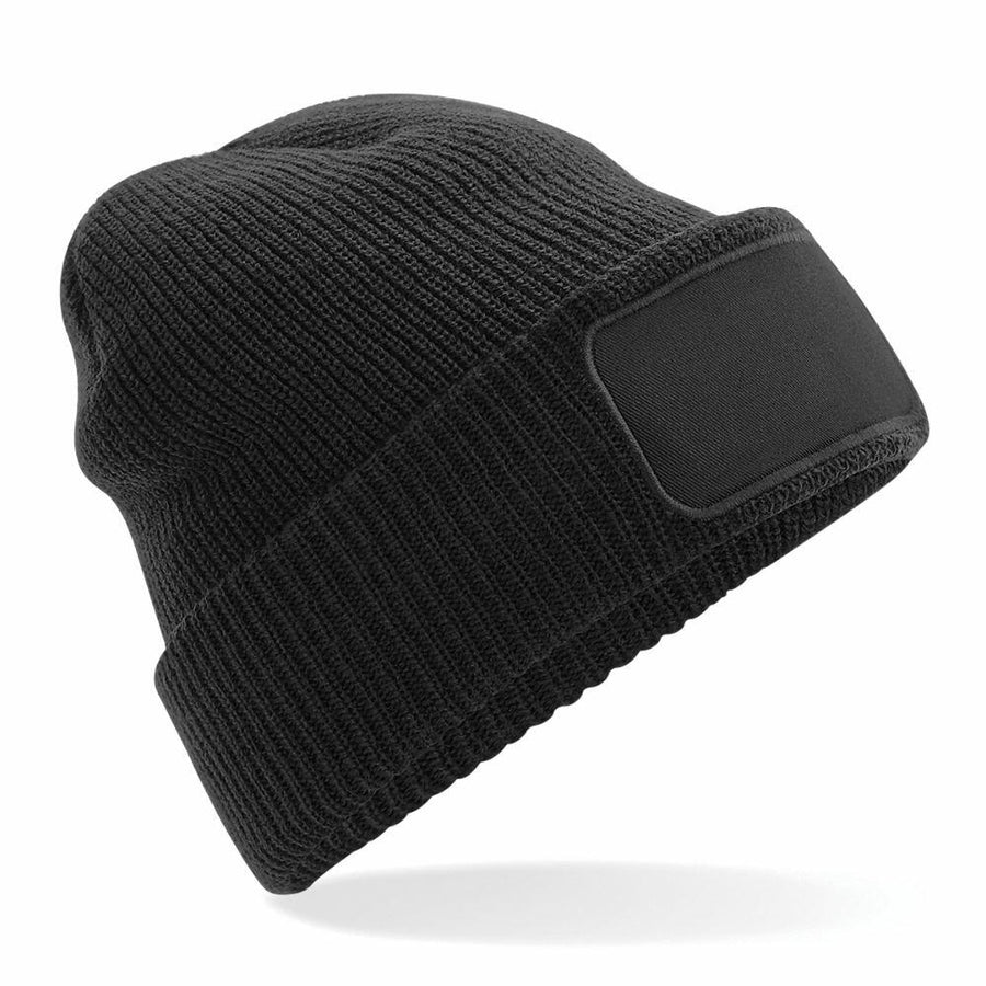 A Beechfield BC440 black knit beanie featuring a blank patch on the front, set against a white background.