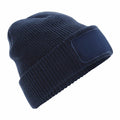 A Beechfield BC440 navy blue knit beanie featuring a folded cuff and a blank patch on the front.