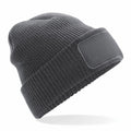 The BC440 Beechfield knit beanie in dark grey features a folded cuff and a blank patch on the front, positioned at an angle against a white background.