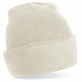 A Beechfield BC445 beige knit beanie featuring a blank rectangular patch on the front.