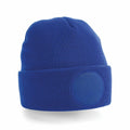 A Beechfield BC446 blue knit beanie featuring a circular patch on the folded brim.