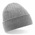 A Beechfield BC447 gray knit beanie with a folded cuff is showcased against a neutral background. The ribbed texture of the fabric lends it a cozy and warm appearance.
