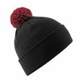 A Beechfield BC450 beanie in black, featuring a red and black pom-pom on top.