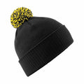 The Beechfield BC450 is a black knit beanie featuring a bright yellow and black pom-pom on top.