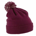 A maroon knit beanie with a pom-pom on top from Beechfield, model BC450.