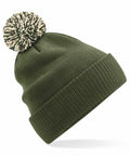 The Beechfield BC450 is a green knit beanie, accentuated with a large, fluffy pom-pom in black and white. It features a folded cuff for added warmth and style. The white background accentuates the texture and vibrant color of the beanie.