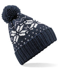 The Beechfield BC456 is a knit beanie colored in navy blue and adorned with white snowflake patterns. It features a pom-pom on top and has a ribbed, folded brim.