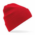 The Beechfield BC45N, a bright red knitted beanie with a folded brim, is displayed against a white background, casting a soft shadow.
