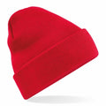 A vibrant red knit beanie from Beechfield, model BC45R, featuring a folded brim against a white backdrop. The beanie is slightly tilted to accentuate its texture and timeless, classic design.