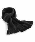 A neatly folded black BC470 with fringe on both ends. The Beechfield scarf is laid out on a white surface, showcasing its texture and knitted pattern.