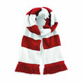 A cozy scarf from Beechfield, product BC479, is made of knitted material featuring red and white horizontal stripes and finished with red fringe tassels at both ends. It is folded neatly against a plain background.