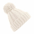 A Beechfield BC480 cream-colored knitted pom-pom beanie featuring a cable knit pattern and ribbed brim, showcased against a white background.