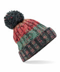 The BC486 by Beechfield is a vibrant knit beanie adorned with a large pom-pom on top, showcasing a blend of red, green, and dark gray patterns. It looks soft and cozy with a ribbed brim.