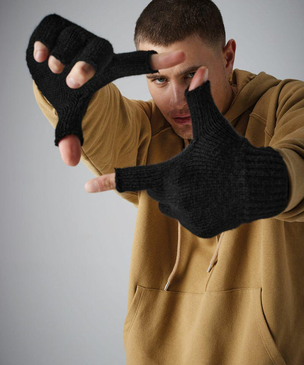 A person wearing a beige hoodie and black Beechfield BC491 fingerless gloves is posing with their hands extended forward, fingers forming a frame. They are looking through the makeshift "frame" created by their hands. The background is plain gray.