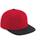 The Beechfield BC661 baseball cap features a vibrant red color with a contrasting black brim and button on top. It is showcased against a clean white background, highlighting both its front and side profiles.