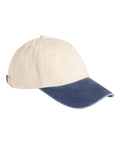 A beige cap with a curved blue denim peak, shown from a front-side angle. Features stitched eyelets and an adjustable back strap.
