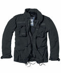 The BD301 military-style jacket by Build Your Brandit, featuring a dark green color with multiple pockets and zippers, is laid flat on a white background.