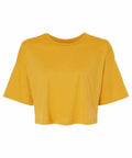 The BE137 by Bella + Canvas is a plain mustard yellow short-sleeve crop top set against a white background. It features a round neckline, loose fit, and slightly dropped shoulders for a relaxed look.