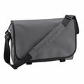 Introducing the Bagbase BG021, a gray messenger bag featuring a black adjustable shoulder strap and a velcro closure. With its simple, sleek design and smooth surface, this bag is perfect for carrying personal items or documents.