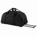 The BG023 by Bagbase is a spacious black rolling duffel bag featuring a zippered front pocket and a detachable metal handle.