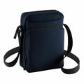 Introducing the Bagbase BG030, a stylish shoulder bag in navy blue featuring black zippers and an adjustable strap.