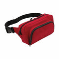 Introducing the Bagbase BG053: a stylish red fanny pack featuring a black adjustable strap and two convenient zippered compartments.