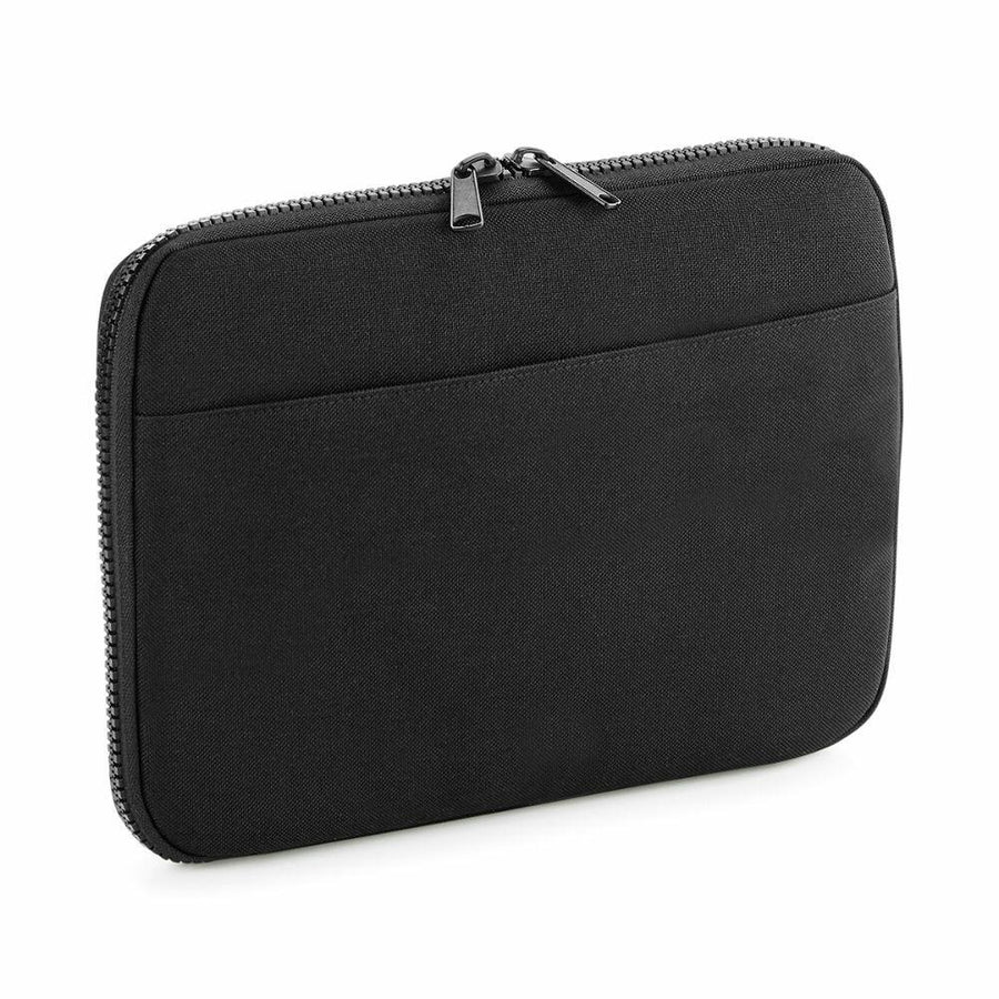 The BG065 by Bagbase is a black zippered tablet or laptop sleeve featuring a front pocket, displayed against a white background.