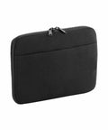 A black zippered sleeve designed to hold a tablet or small laptop. The BG065 by Bagbase has a streamlined design with a zip closure on the top edge and an extra front pocket for additional storage. The material appears to be neoprene or a similar fabric.