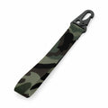 The Bagbase BG100 is a camouflage-patterned fabric keychain strap featuring shades of green, brown, and black. It comes with a black metal clip designed for easy attachment to keys or bags.