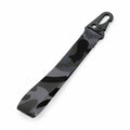The BG100 keychain strap from Bagbase features a camouflage pattern in shades of green, gray, and black, complete with a black metal clip on one end for a military-style look.