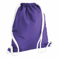 A Bagbase BG110 backpack in purple, featuring white drawstrings, is shown from the back. The bag is upright with the strings casually draped around it. Its fabric looks smooth and slightly shiny.