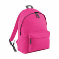 The Bagbase BG125 is showcased against a white background, featuring a vibrant pink design with adjustable black straps, a small front pocket, and a main zippered compartment.