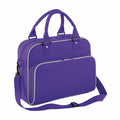 The BG145 by Bagbase is a purple laptop bag equipped with two handles and an adjustable shoulder strap. It boasts two main zipped compartments, including a front pocket with an additional smaller zip, all accentuated by contrasting zippers for a sleek design.