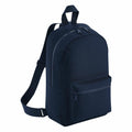 The Bagbase BG153, a sleek black backpack featuring a front zippered pocket and adjustable shoulder straps, is displayed against a white background.