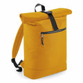 The BG286, a mustard yellow backpack from Bagbase, showcases a roll-top design with a zippered front pocket, black adjustable shoulder straps, and a black buckle fastening on the roll-top. Its sturdy material makes it ideal for casual use.