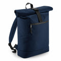 The Bagbase BG286 backpack is designed in a dark blue color with a black buckle strap and a zippered front pocket. It features adjustable shoulder straps, offering a minimalist design that provides a modern and functional appearance.