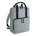 Introducing the Bagbase BG287, a stylish backpack in light gray with black zippers and handles. It boasts a spacious main compartment, a front pocket with double zippers, and adjustable shoulder straps, offering a simple and functional design.