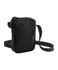 The Bags crossbody features a sleek, minimalist black design with a zippered front pocket and adjustable shoulder strap, shown standing upright against a plain white background.