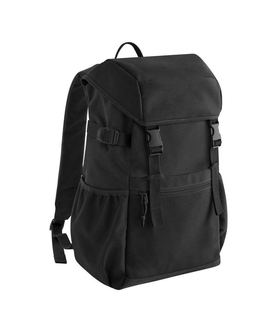 The Bags rucksack features a black design with a top flap secured by dual buckle straps, side pockets, a front zip pocket, and adjustable shoulder straps, shown against a white background.