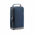 The Bagbase BG540 shoe bag is blue and gray, featuring a top handle and a zippered side closure. It includes a small grommet hole near the top and has a side pocket with a zipper pull.