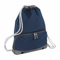 Introducing the Bagbase BG542: a stylish dark blue drawstring backpack highlighted by sophisticated grey accents. It comes equipped with white drawstring straps and a convenient front zippered pocket featuring two zipper pulls, while black grommets adorn the bottom corners for added durability.