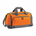 The Bagbase BG544 is a bright orange and gray duffel bag featuring a spacious main compartment, top handles, an adjustable shoulder strap, and a front zippered pocket. It also includes ventilation eyelets at the bottom for added practicality.
