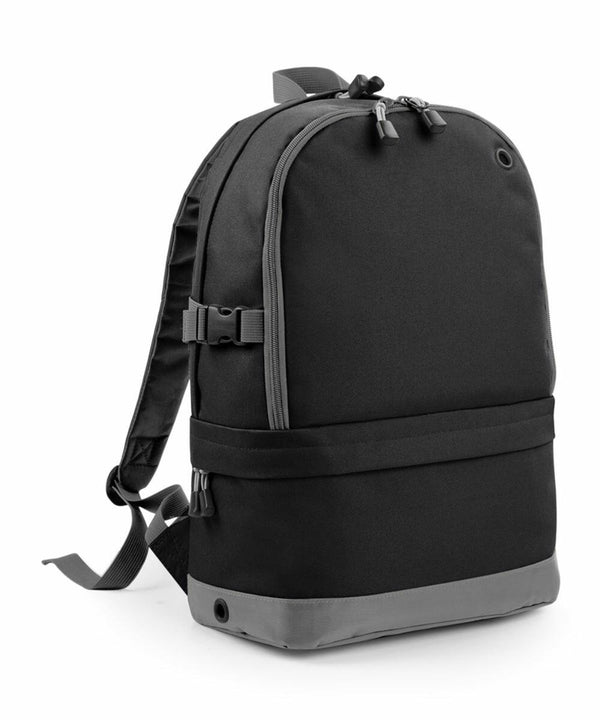 A black and gray BG550 backpack by Bagbase with multiple compartments and adjustable straps, displayed on a plain white background.